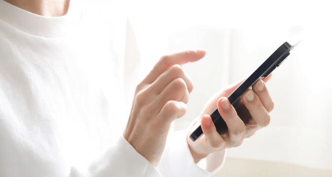 手元でスマートフォンを操作する様子